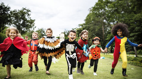Verkleidete Kinder rennen über Wiese